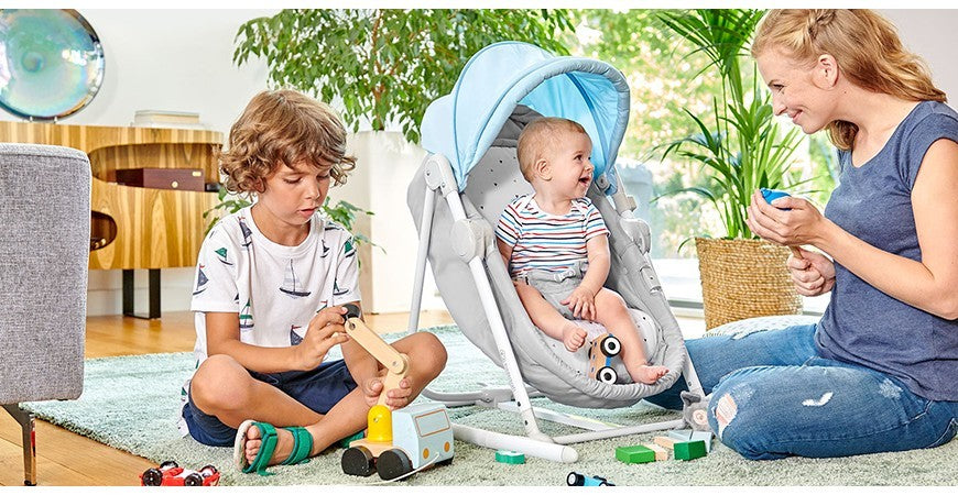 Photo d'un enfant assis dans sa transat entouré de sa famille Babykare.fr